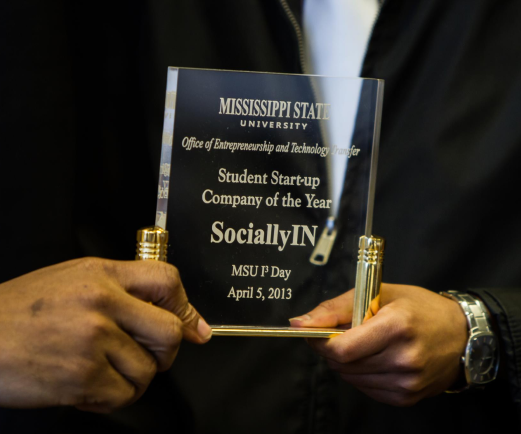 Man holding plaque that reads "Student Startup Company of the Year" at Mississippi State University