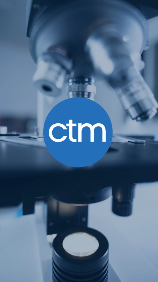 A microscope with the CTM logo in the background