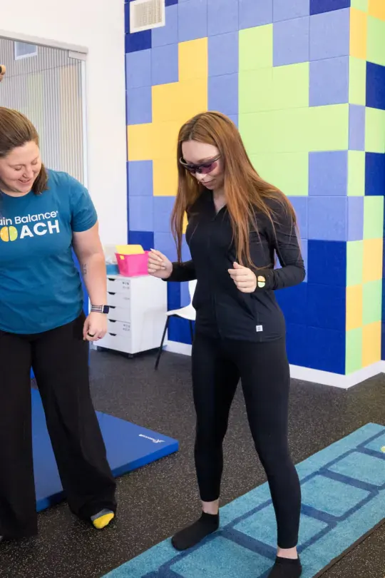 A coach and a teenager doing a floor-pattern activity in a center