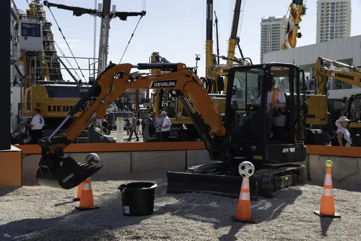 A DEVELON excavator with traffic cones